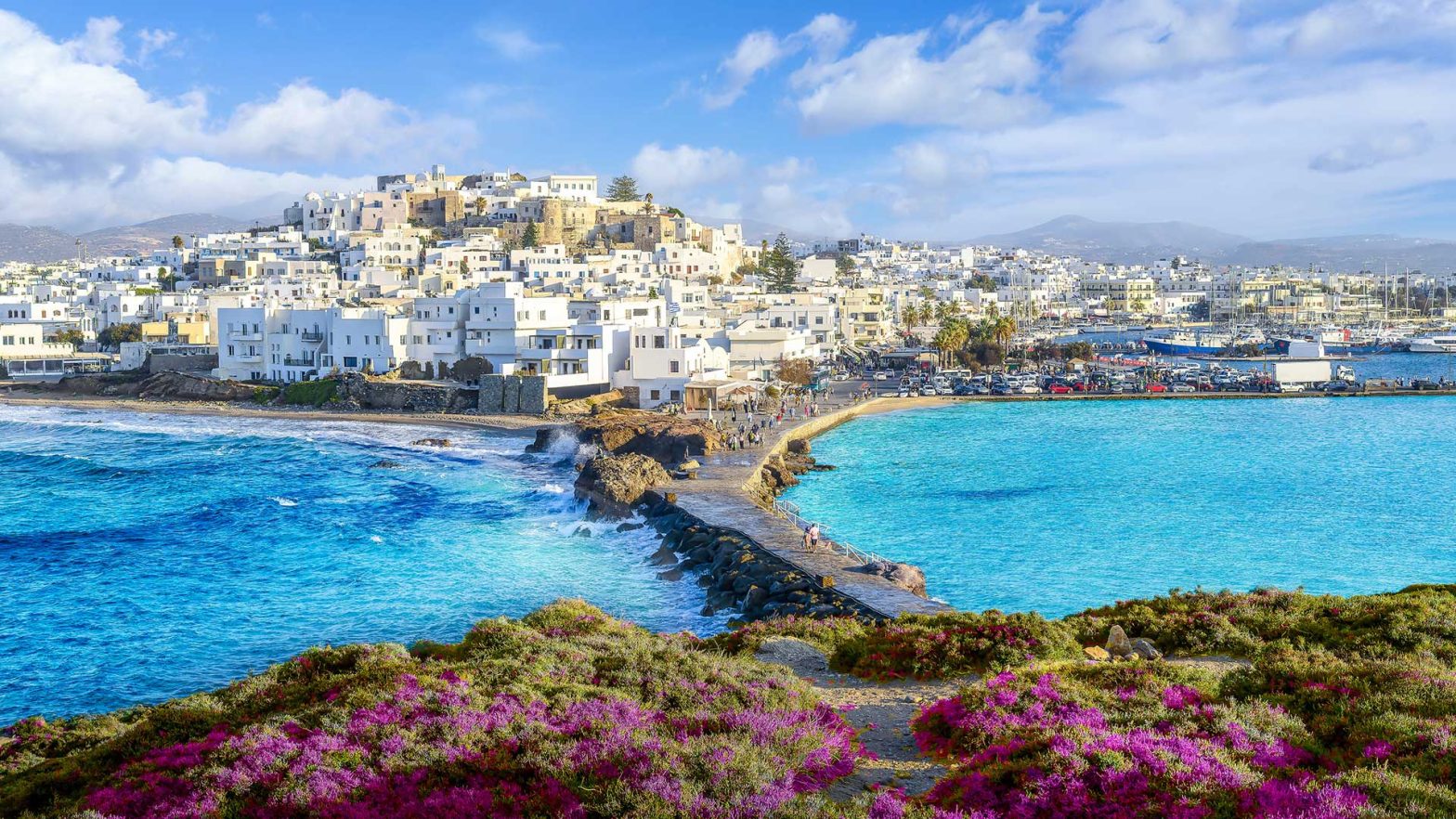The white buildings, fertile grasses and crystal blue waters of Naxos, Greece.