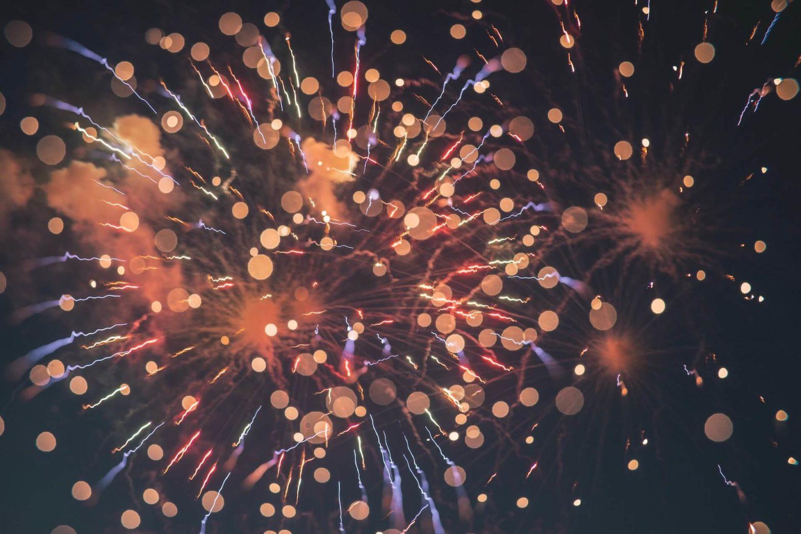 multicolored fireworks and confetti with a black sky background