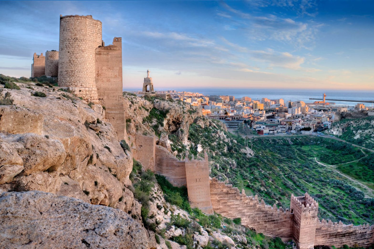 The Alcazaba of Almería, an ancient fortress, stands majestically over the city with views extending to the Mediterranean Sea at sunset.
