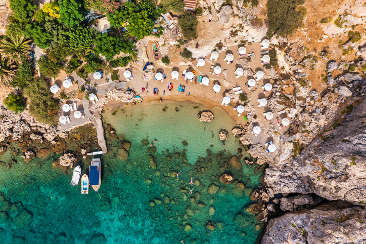 beach from above with umbrellas and boats on the island of rhodes