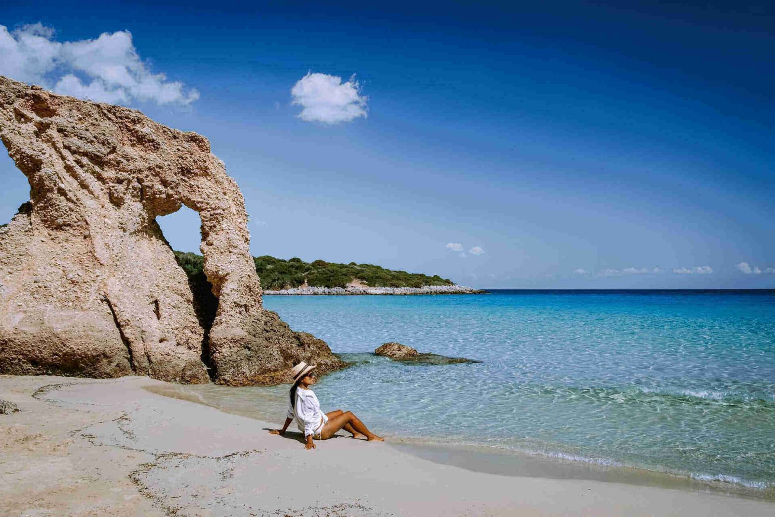 Donna sulla spiaggia con cielo azzurro