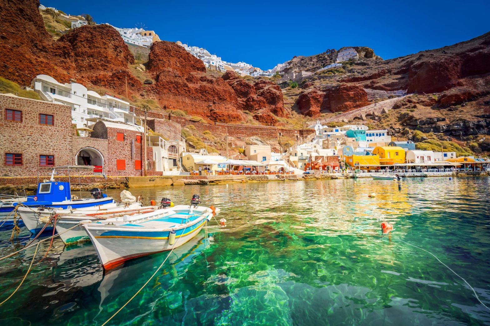 Σαντορίνη όρμος Αμμούδι, πολύχρωμες βάρκες, καταγάλανα νερά