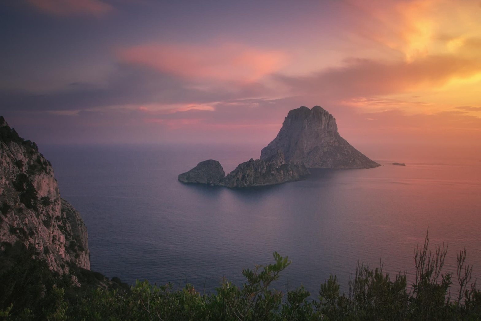 Tramonto mozzafiato su Es Vedrà, l’iconico isolotto roccioso al largo della costa di Ibiza, Spagna.
