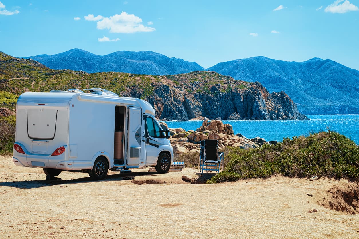 Wohnmobil auf Sardinien mit Blick auf das Meer und die felsige Küste.