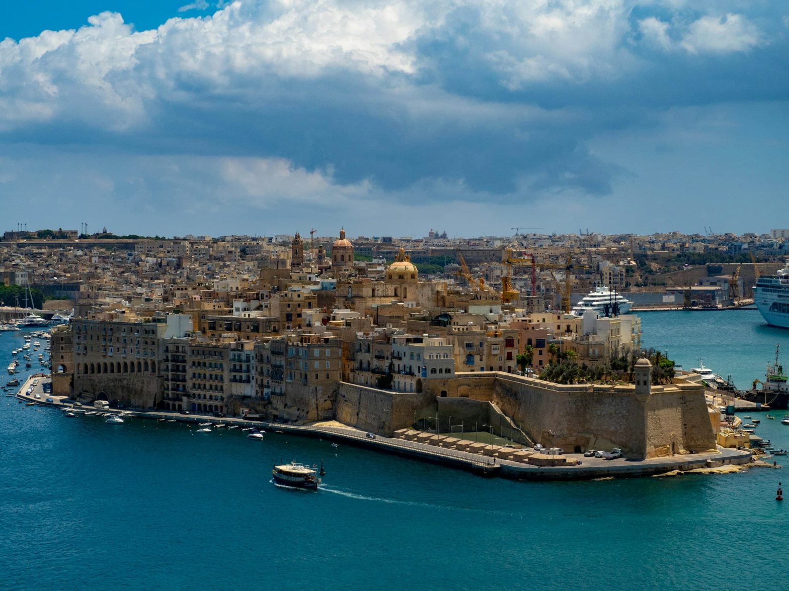Veduta panoramica de La Valletta, capitale di Malta, con le sue fortificazioni storiche, chiese barocche e il porto sul Mar Mediterraneo.